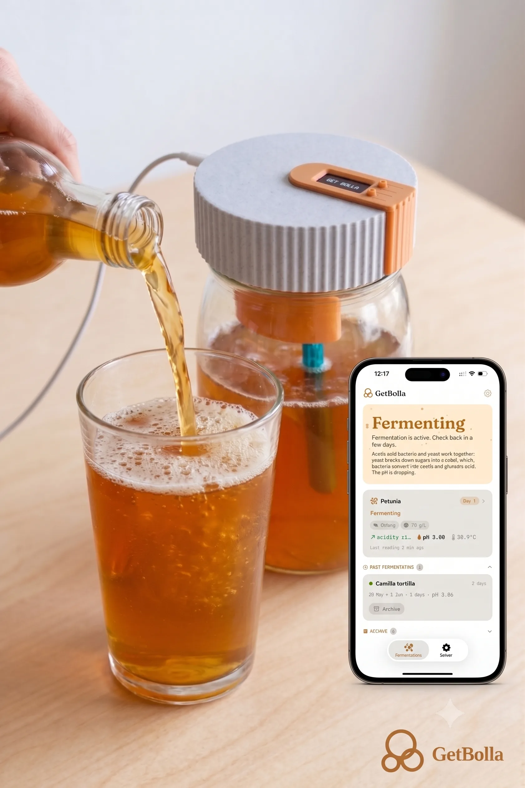 Bottiglia di kombucha artigianale e barattolo con sensore GetBolla su un tavolo di cucina, con l'app GetBolla aperta su uno smartphone
